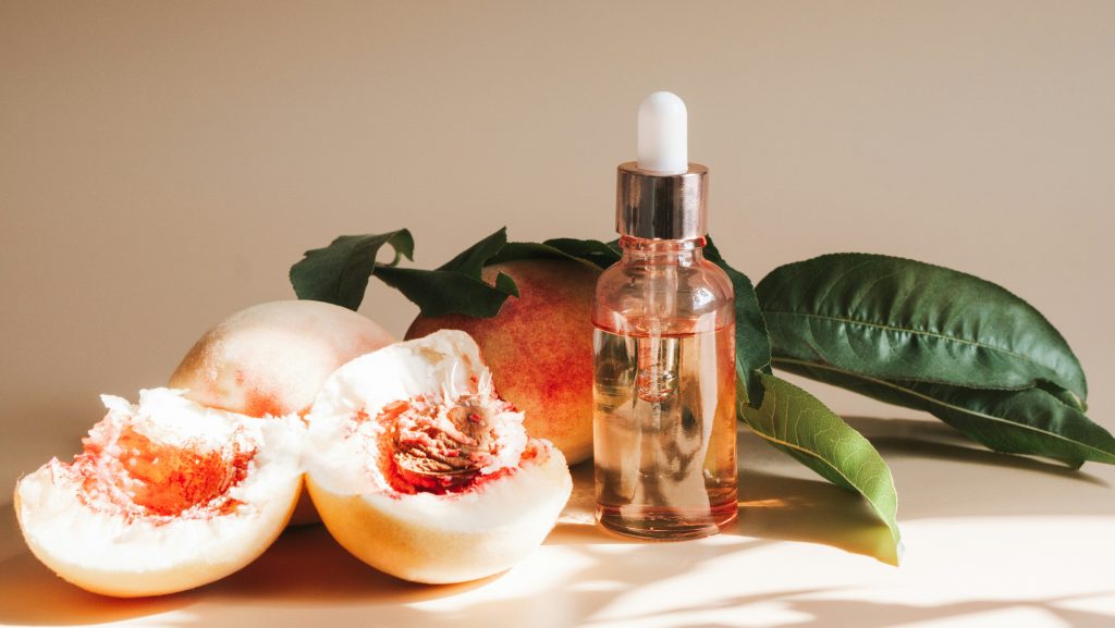 A bottle of lotion sitting next to some fruit