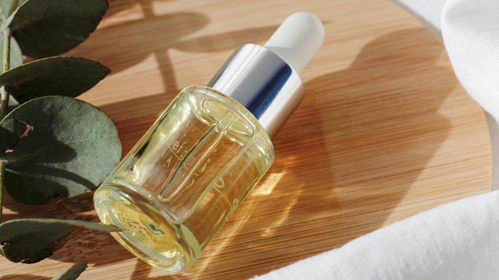 clear glass bottle on white textile